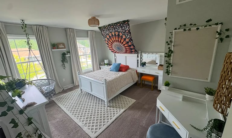 organized bedroom with decorations hanging from ceiling.