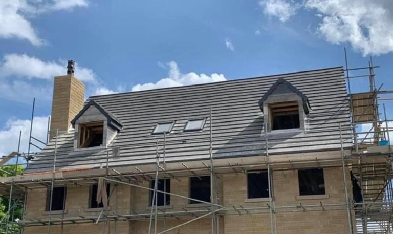 Roofing Specialist Yorkshire. showing a new roof being installed on a house with 2 dormer windows