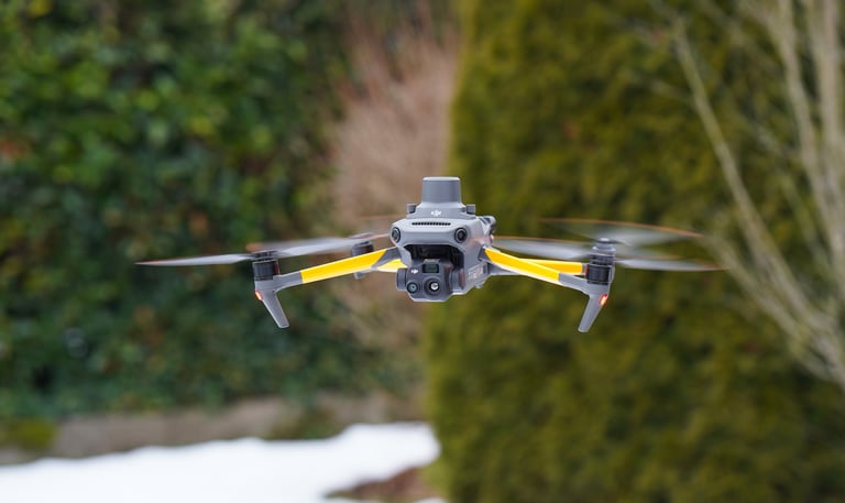 Professional DJI Mavic 3 thermal drone hovering outdoors against a blurred green hedge background.