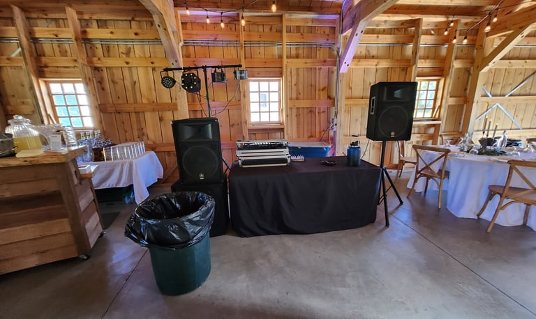 a dj booth with speakers and a table with a table cloth