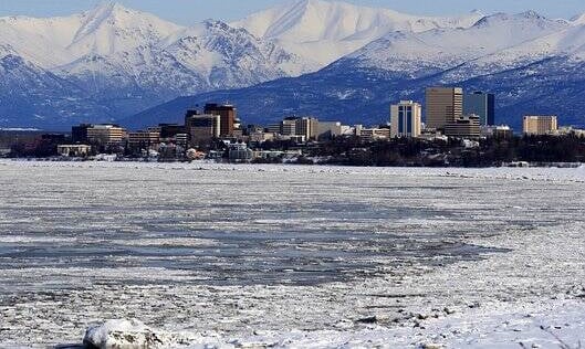 Anchorage, AK - A view of the city of Anchorage in winter with mountains in the background