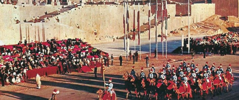a group of people in a parade in front of a castle