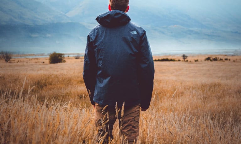Man in open field contemplating nature