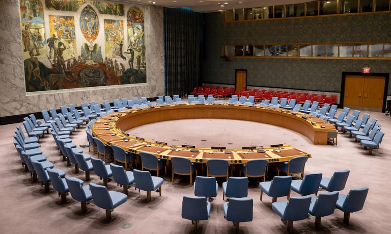 Sala de consejo internacional con mesa circular y asientos dispuestos para deliberación multilateral