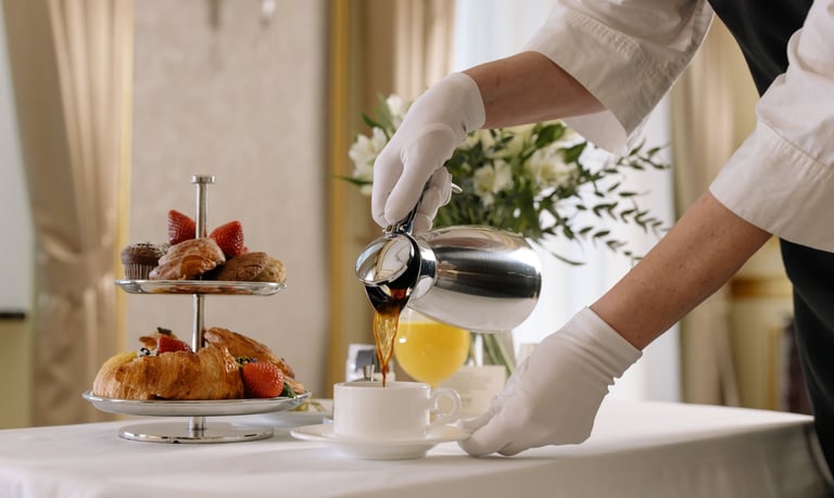 Gloved server pouring tea for a guest