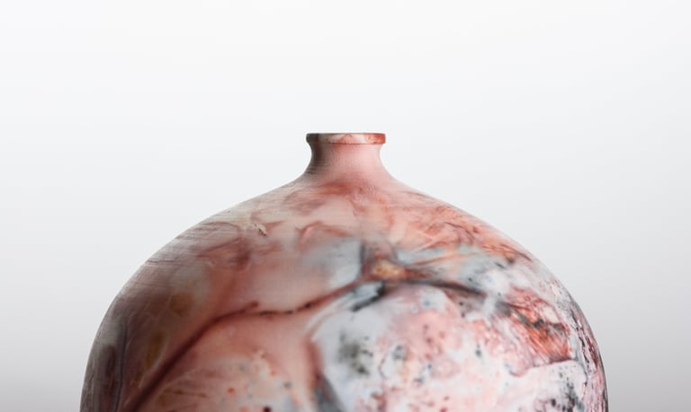 Handmade pit-fired ceramic vase with a unique marbled red and grey smoky finish on a white background.