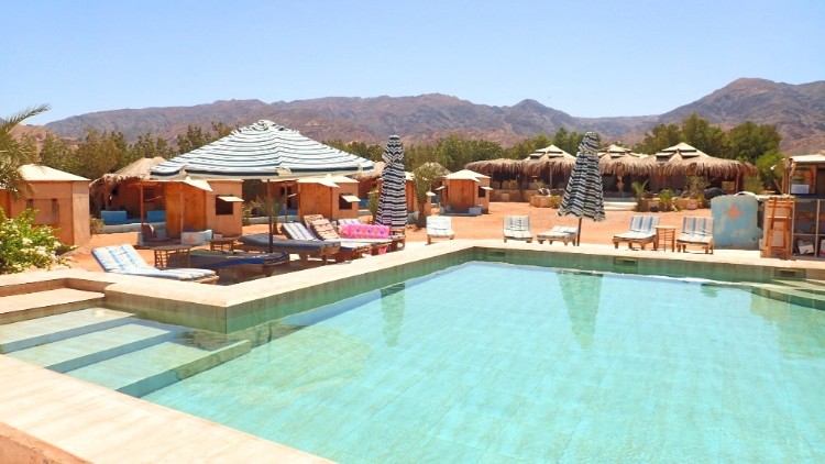Beach with pool and lounge chairs and umbrellas