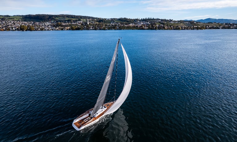 Esse 330 sailboat sailing downwind with a gennaker on calm Lake Zurich