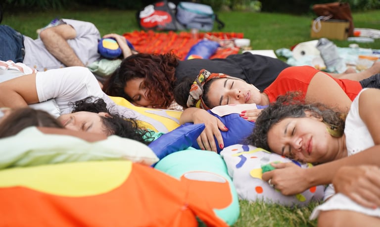 People rest on soft sculptures of body parts.