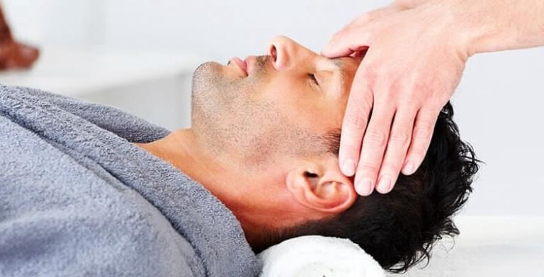 um homem recebendo massagem na cabeça