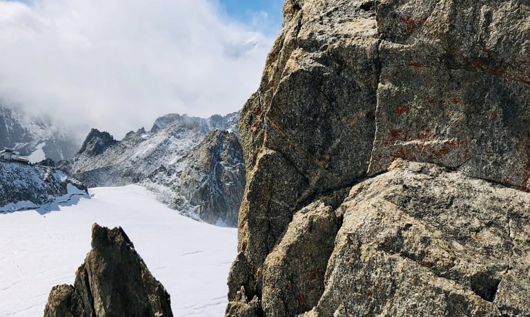 a person standing on a mountain top with a mountain in the background