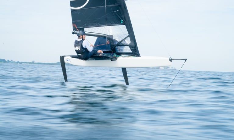 a man is sailing a sailboat in the ocean