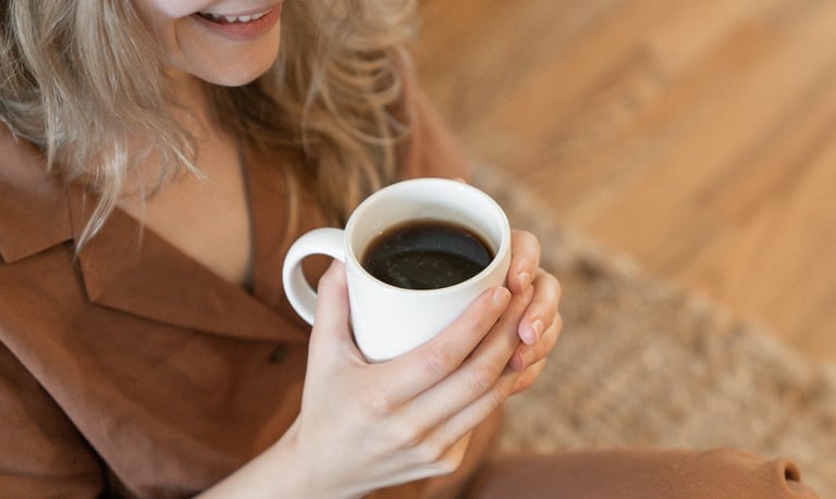 A woman enjoying a cup of black coffee