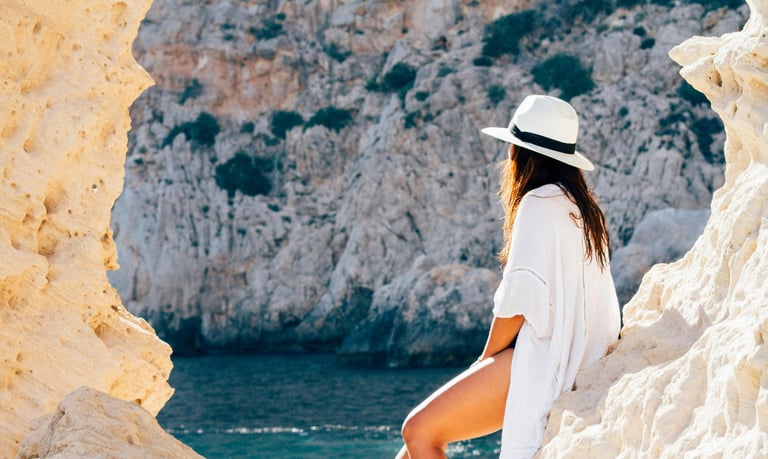 A woman wearing a white shirt and white cap on vacation