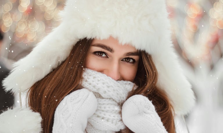 Woman in winter coat and hat out in the snow.