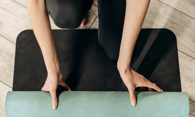 Woman in black leggings with a workout mat for pilates