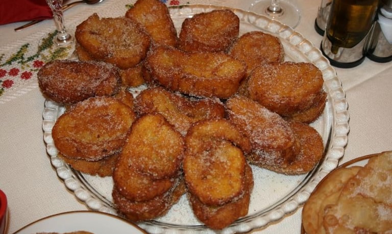 a plate of rabanada and a glass, food table