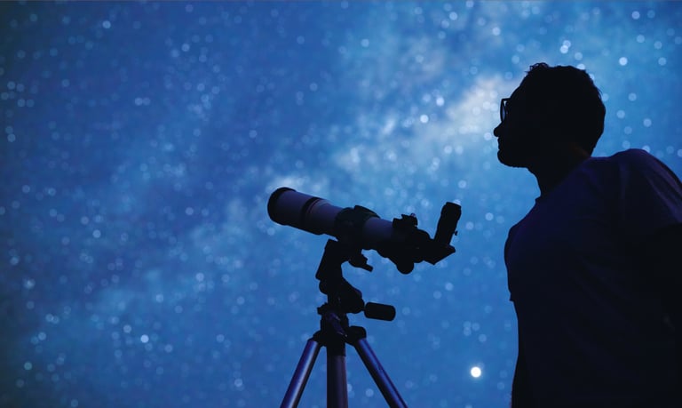 a man standing in front of a telescope