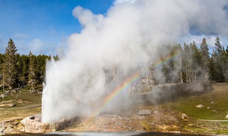 a colored rainbow - water spewing out of a geyser