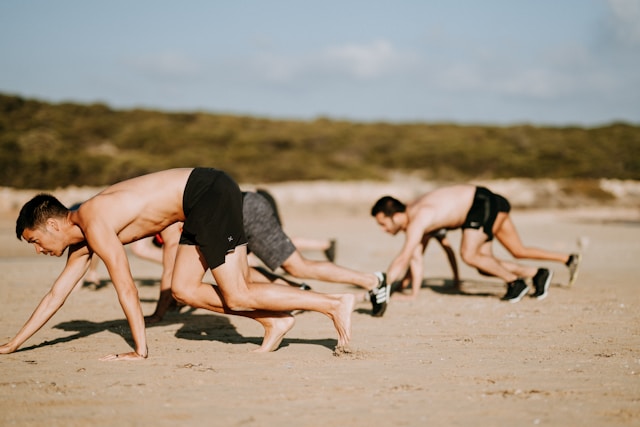 men bear crawling on the beach at a fitness class