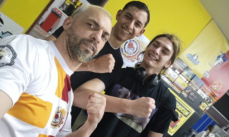 Three smiling athletes posing with fists up inside a local gym with yellow walls.
