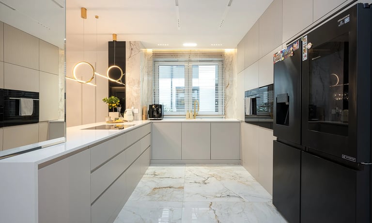 Nowoczesna jasna kuchnia z szarymi szafkami, białym blatem, czarną lodówką i oknem.