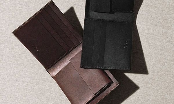 Carteras abiertas de cuero negro y marrón de dos pliegues con ranuras para tarjetas.