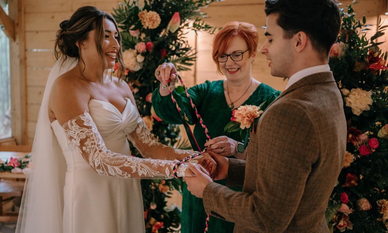 Celebrant leading a handfasting ceremony with a wedding couple