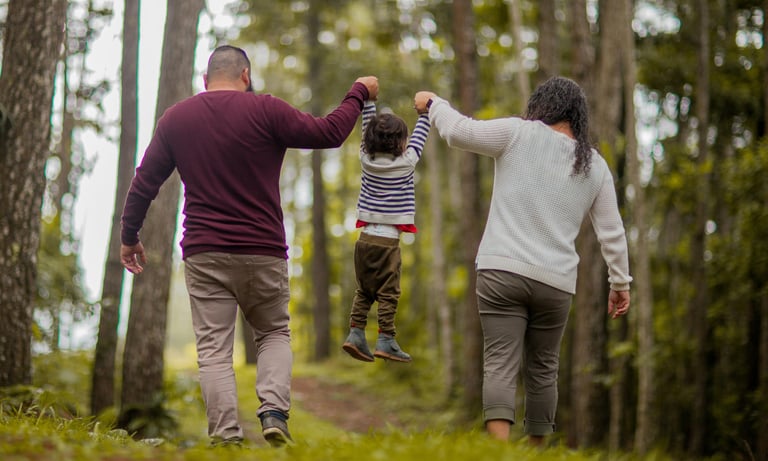 Parents and child walking through a woodland