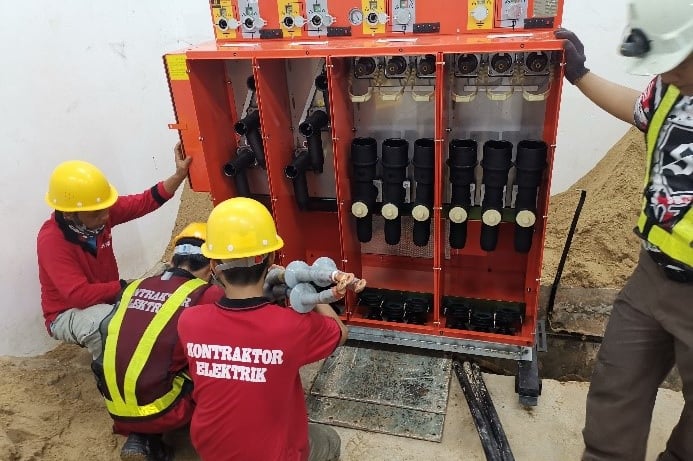 Electricians installing switchgear in a TNB substation