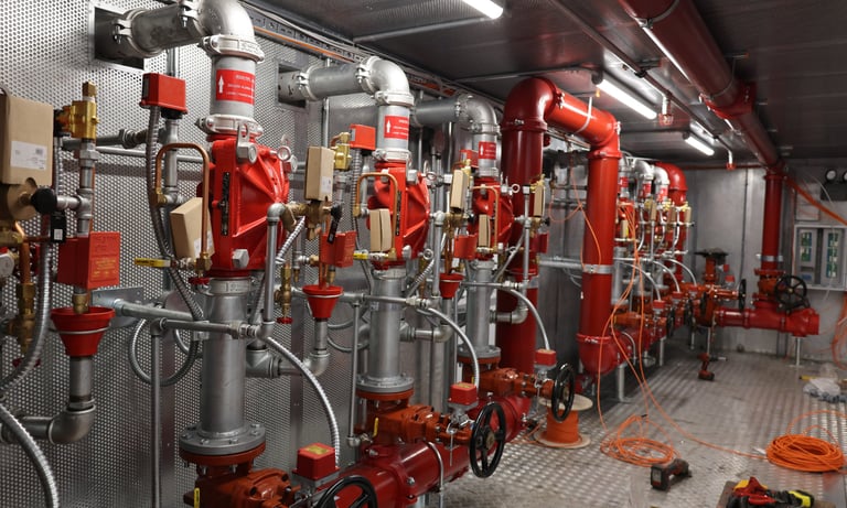 a bunch of red fire hydrant pipes and pipes