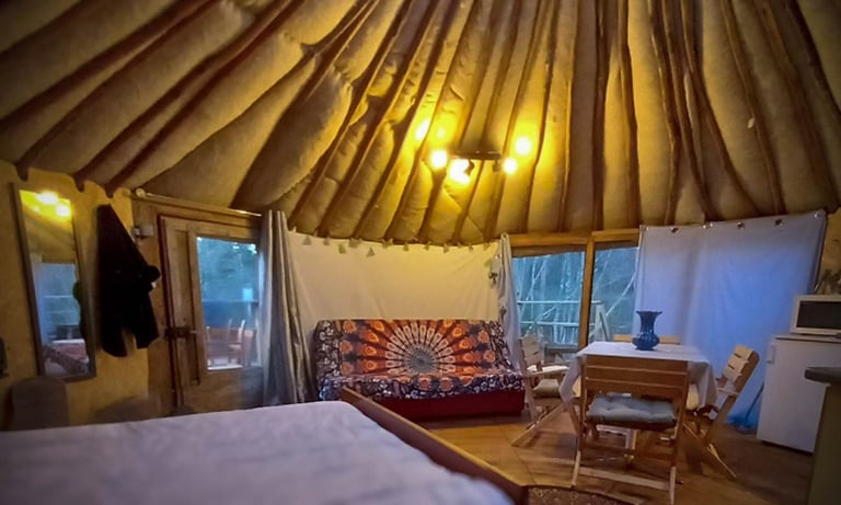 intérieur d'une yourte en fin de journée avec les lumières tamisées allumées