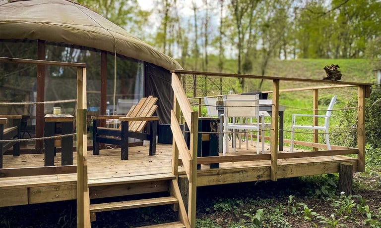 extérieur d'une yourte avec terrasse bois et espaces avec tables et chaises