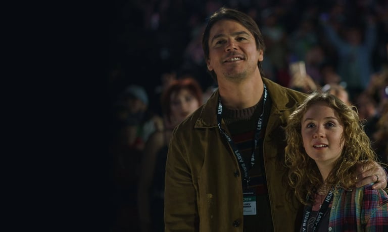 A man holds his daughter at a concert