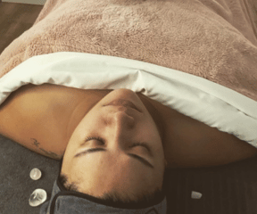 Madame recoit Un massage à base de pochons d'herbes chaudes.