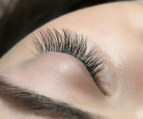 femme recevant un service de pose de cils dans un salon de beauté professionnel d'extensions de cils