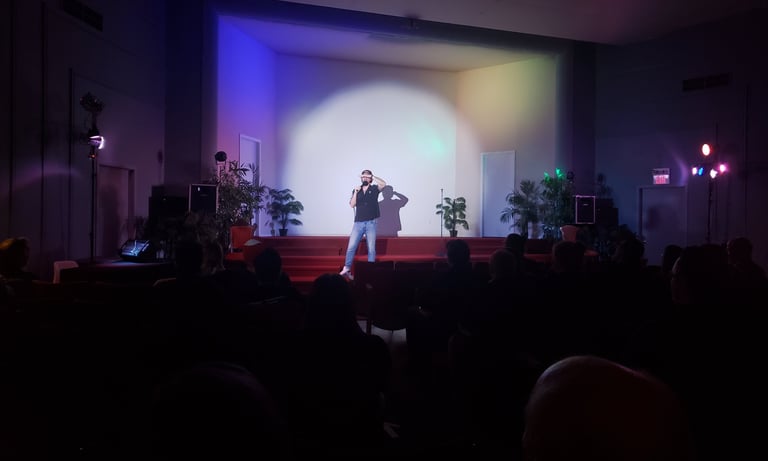 a man standing on stage with a microphone and a microphone