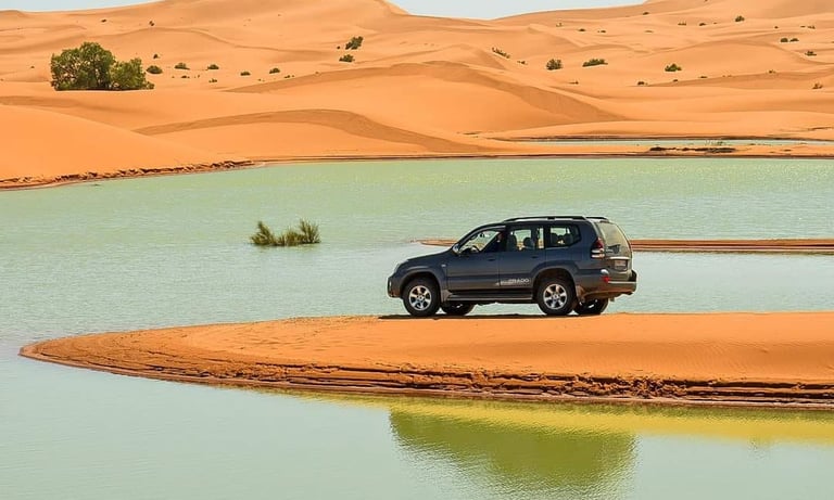 morocco sahara a car parked in a desert with a car in the background