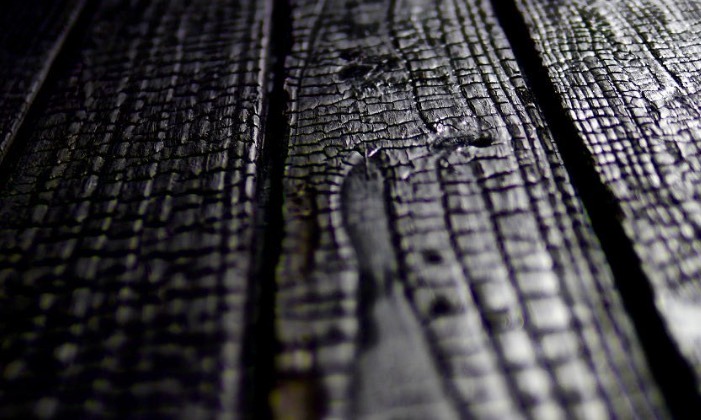 Close-up of charred wood texture with black burnt Shou Sugi Ban timber patterns.