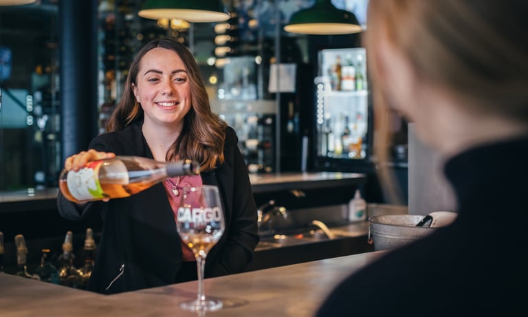 Serveuse qui sert un verre dans le but d'illustrer le site web de l'hôtel