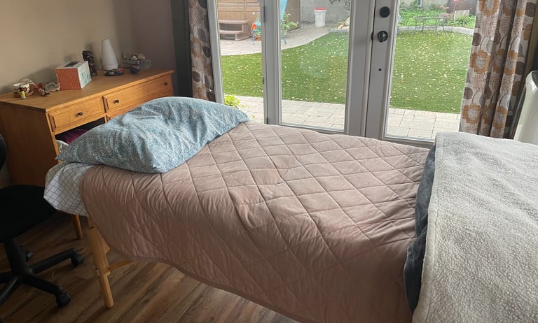 Massage table with pink blanket in a treatment room