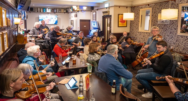 Scottish folk music players in a pub setting