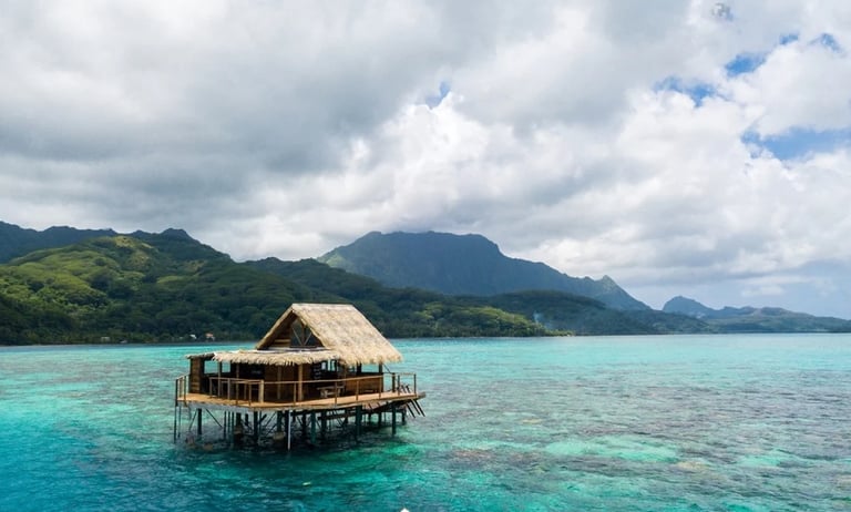 tahitian landscape with house on stilts over turquoise water
