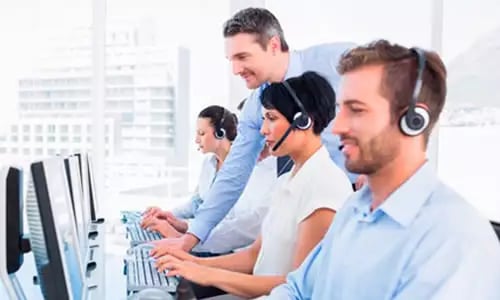 a group of people in a call center with headsets and headsets