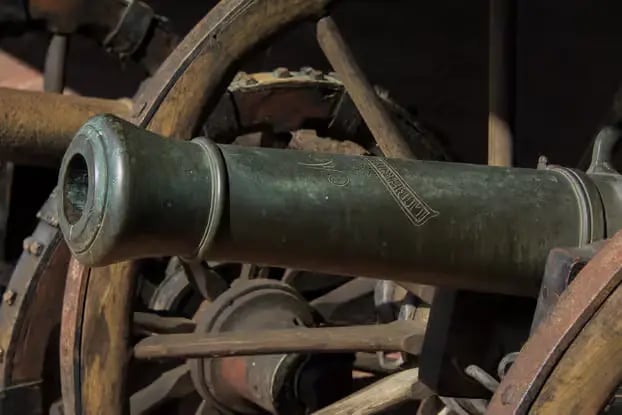 Close-up of an antique bronze cannon on a wooden artillery carriage