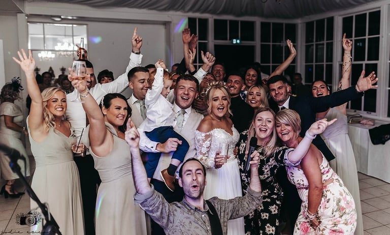 bride and group having fun with wedding singers and band