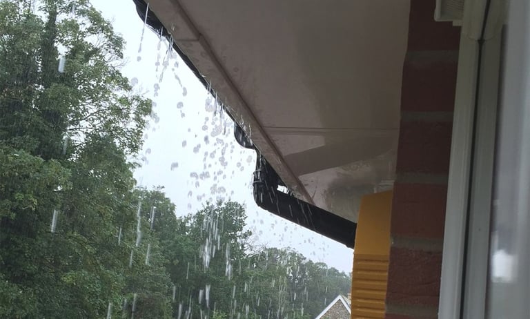 Rain water over spilling a compromised gutter