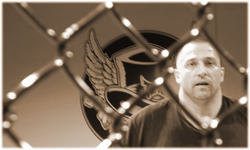 a man in a black shirt is looking at the camera
