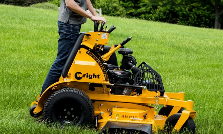 Wright Stander X mower with a team member mowing grass.