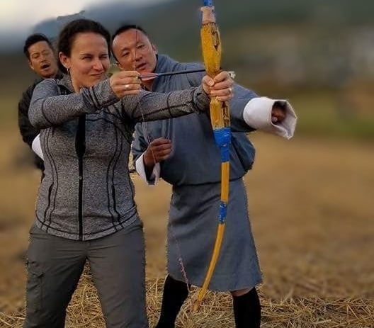 Drukyul_Delights_CEO_with_Guest_trying_traditional_Bow_and_arrow_during_guided_Archery_Session